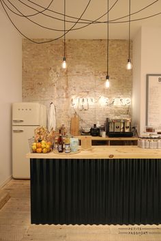 an open kitchen with lots of food on the counter and hanging lights over it's counters