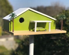 a green bird house with a car in it