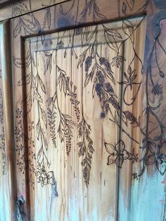 an old wooden door with vines painted on it