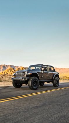 the jeep is driving down the road in the desert