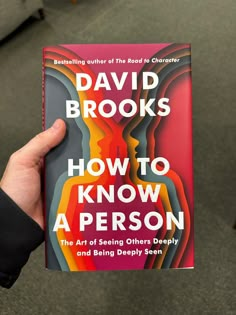 the book how to know a person by david brooks is held up in front of a chair