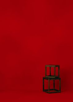 a small wooden chair sitting on top of a red floor in front of a red wall