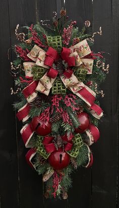 a christmas wreath hanging on the side of a wooden fence with red and green decorations