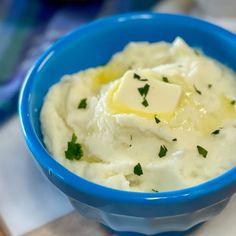 a blue bowl filled with mashed potatoes and butter