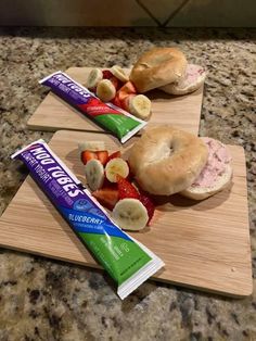 two sandwiches with fruit and peanut butter on them sitting on a cutting board next to a bar of toothpaste