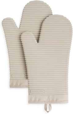 three oven mitts are shown on top of each other, one is white and the other is beige