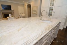 a large kitchen with marble counter tops and white cabinets