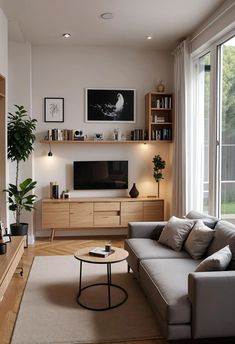 a living room filled with furniture and a flat screen tv on top of a wooden shelf