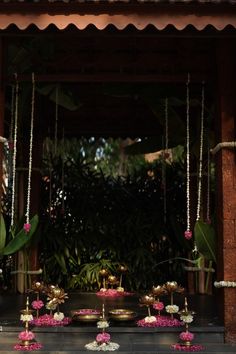 an outdoor ceremony setup with candles and flowers on the table, surrounded by greenery