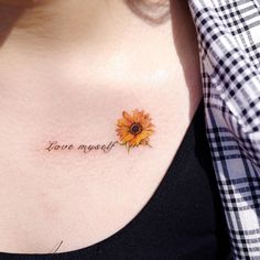 a woman's chest with a sunflower tattoo on her left shoulder and the words love my self written in cursive font