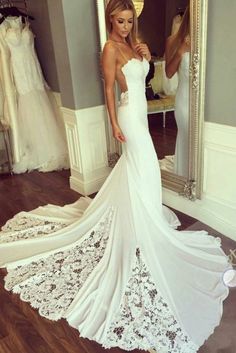 a woman in a wedding dress looking at herself in the mirror