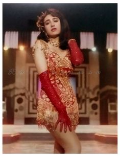 an old photo of a woman in a red and gold dress with her hands on her hips