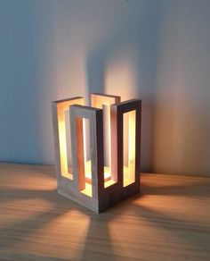 a light that is sitting on top of a wooden table in front of a wall