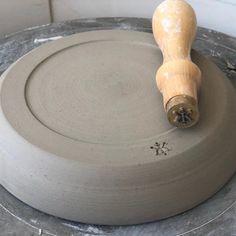 a wooden handle sitting on top of a gray object in the middle of a circle