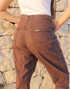 Mom jeans in brown. High rise. Zipper fly. Front and back pockets. Tapered leg. Size EU 40 / UK 12 Actual measurements - 30"(76cm) waist - 40"(102cm) hips - 30.5"(77cm) inner leg - 13"(33cm). Composition - 100% Cotton Condition - Excellent. Sustainability - Vintage Handpicked, repaired and ready to wear. This is an original vintage item, not new and minor signs of wear and age are expected, we will highlight any major flaws. Model is a size UK 6/8 and is 5'7" tall Mid-rise Brown Pants With Belt Loops, Brown Tapered Leg Jeans With Five Pockets, Brown Mid-rise Pants With Belt Loops, Mid-rise Brown Pants With Hip Pockets, Casual Brown Tapered Leg Jeans, Brown Mid-rise Pants With Hip Pockets, Brown Straight Leg Denim Jeans, Brown Five Pocket Denim Jeans, Brown Jeans With Belt Loops For Fall