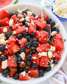 watermelon, blueberries and feta cheese salad in a bowl with spoon