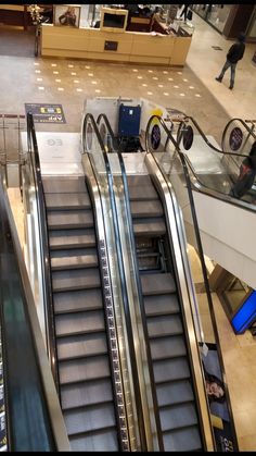 an escalator in a shopping mall with people walking up and down the stairs