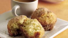 two muffins on a plate with a cup of coffee