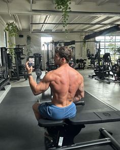 a man sitting on top of a bench in a gym