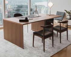 an office desk with two chairs and a laptop on it in front of a large window