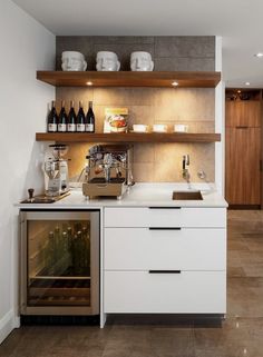 a kitchen with open shelving and wine bottles on the shelves above the stove top