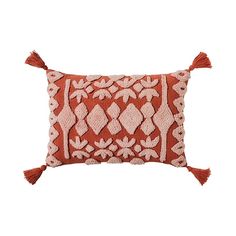 an orange and white pillow with tassels