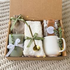 a gift box with tea, coffee mugs and other items in it on a carpeted surface