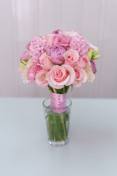 a vase filled with pink flowers on top of a table