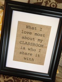 a black frame with a quote on it sitting next to a pillow and wallpaper