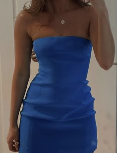 a woman in a blue dress talking on her cell phone