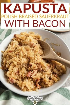 a bowl filled with sauerkraut and topped with bacon next to a wooden spoon