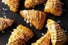 several pastries with white icing on a black surface