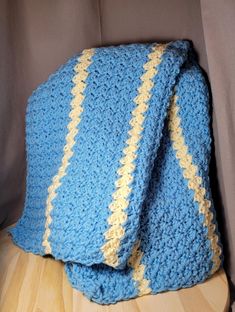 a blue crocheted blanket sitting on top of a wooden table