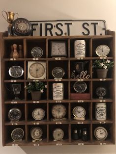 a wooden shelf filled with lots of different types of clocks