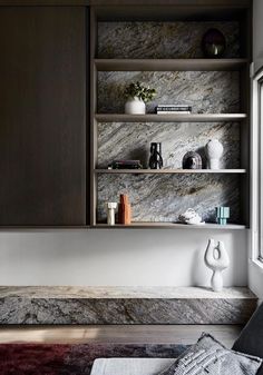 a room with some shelves and vases on the wall