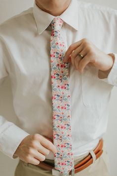 a man wearing a white shirt and floral tie