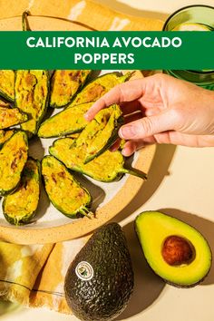 an avocado cut in half on a plate with the words california avocado poppers