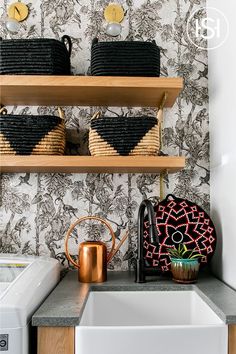 the kitchen is decorated with black and white wallpaper, gold accents, and wooden shelves