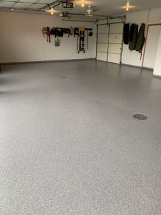 an empty garage with several coats hanging from the ceiling