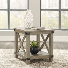 a table with a plant and a book on it in front of a large window