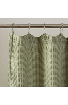 a green curtain hanging from a metal rod