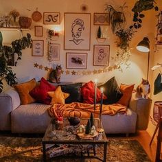 a cat sitting on top of a couch in a living room next to a table