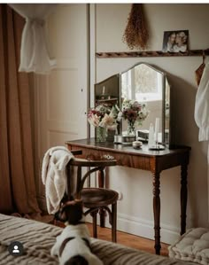 a dog is sitting on the bed looking at it's reflection in a mirror