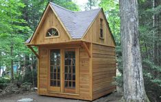 a small wooden cabin in the woods surrounded by trees