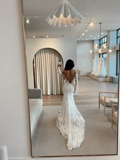 a woman is taking a selfie in front of a mirror wearing a wedding dress