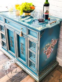 a blue painted buffet with fruit and wine on top