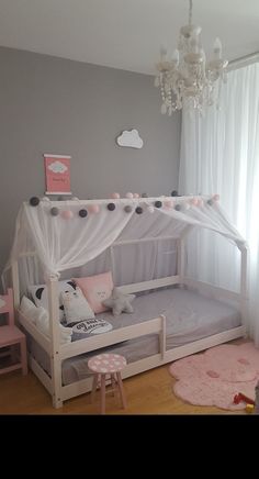 a child's bedroom with a white canopy bed and pink rugs