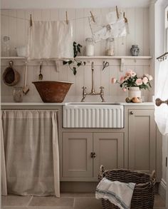 a kitchen with white walls and wooden cabinets, an old fashioned dishwasher is on the counter