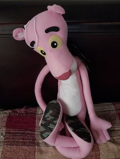 a pink stuffed animal sitting on top of a bed