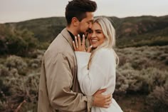 a man and woman embracing each other in the desert